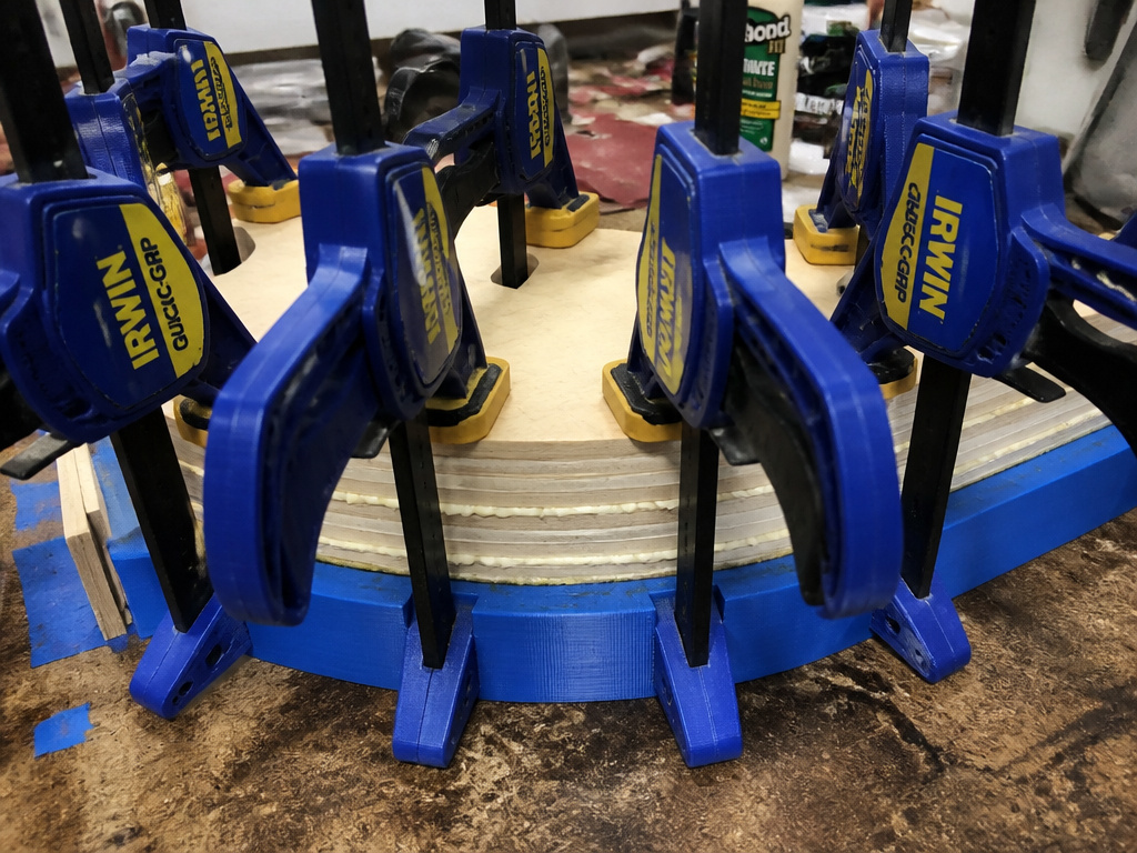 DIY skateboard deck being cold-pressed with clamps in a custom mold